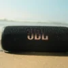 JBL Flip 6 sendo usada na areia da praia